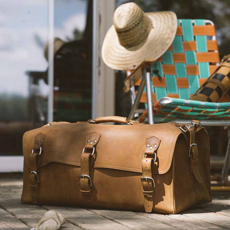 This full grain leather duffle bag "The Adolescent Beast" is ideal for a week or longer of travel, and features a lined interior with two pockets, comfortable carry handle, and adjustable shoulder strap.