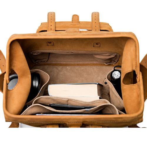 This leather backpack is staying open and showing the light tan interior.