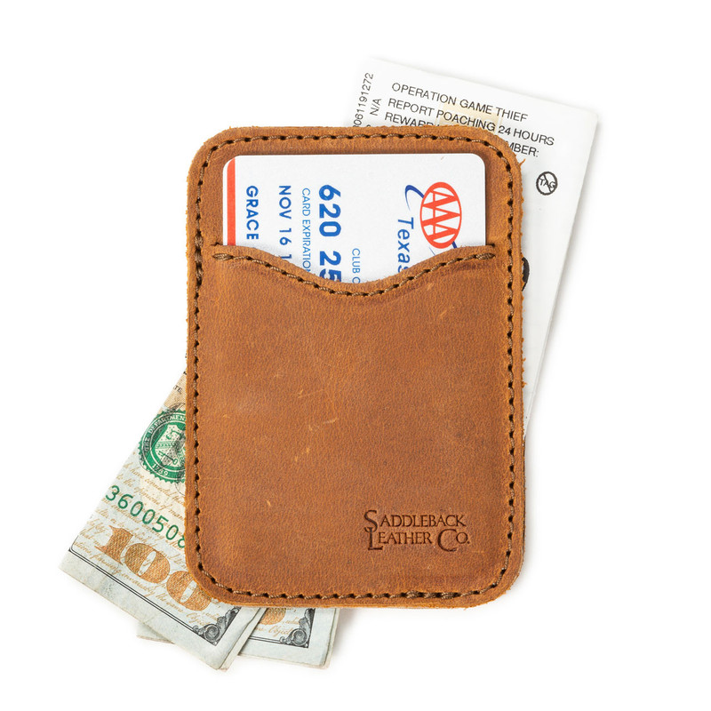 This is a tan brown leather wallet open with cash sticking out both ends.