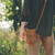 This is a tan brown leather satchel that is thin from the back side hip.