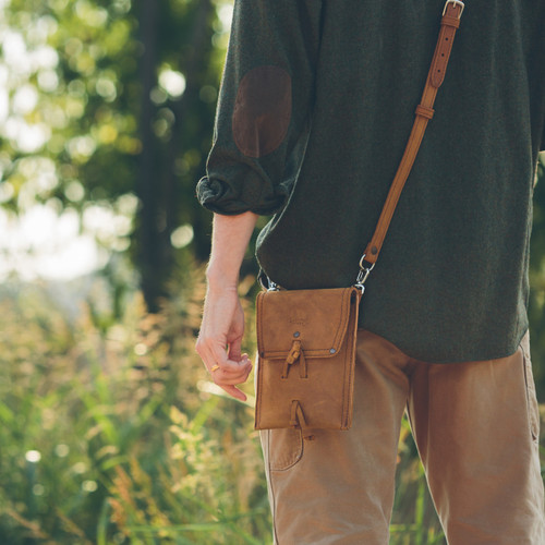 This is a tan brown leather satchel that is thin from the back side hip.