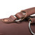This is the top view of the hardware on a reddish brown rounded leather satchel.