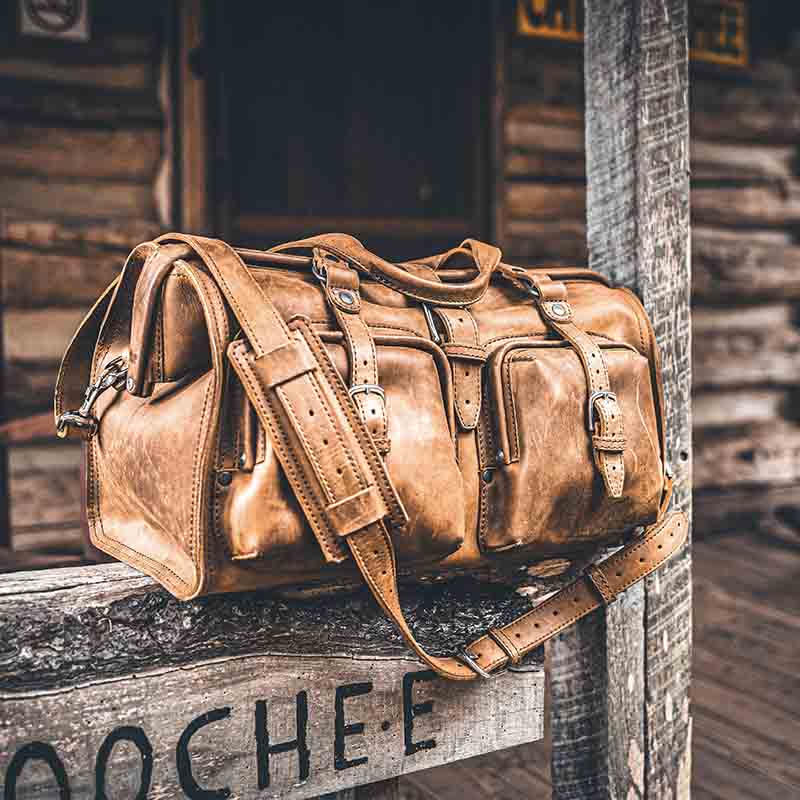 The full grain leather duffle bag is designed with deep pockets to fit in overhead compartments on planes.