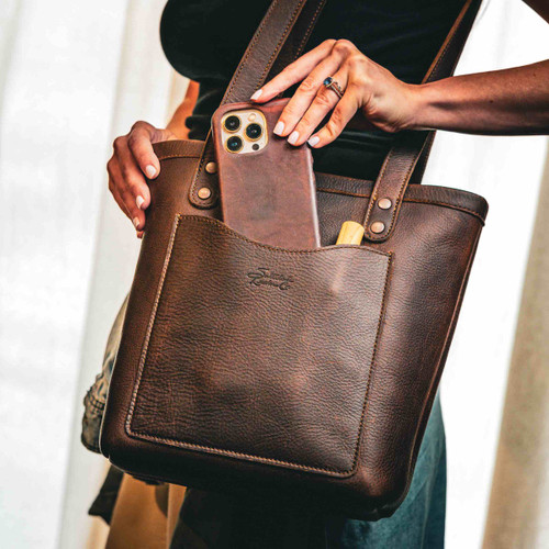 The leather Sunday Tote showing an iPhone in the outside pocket.
