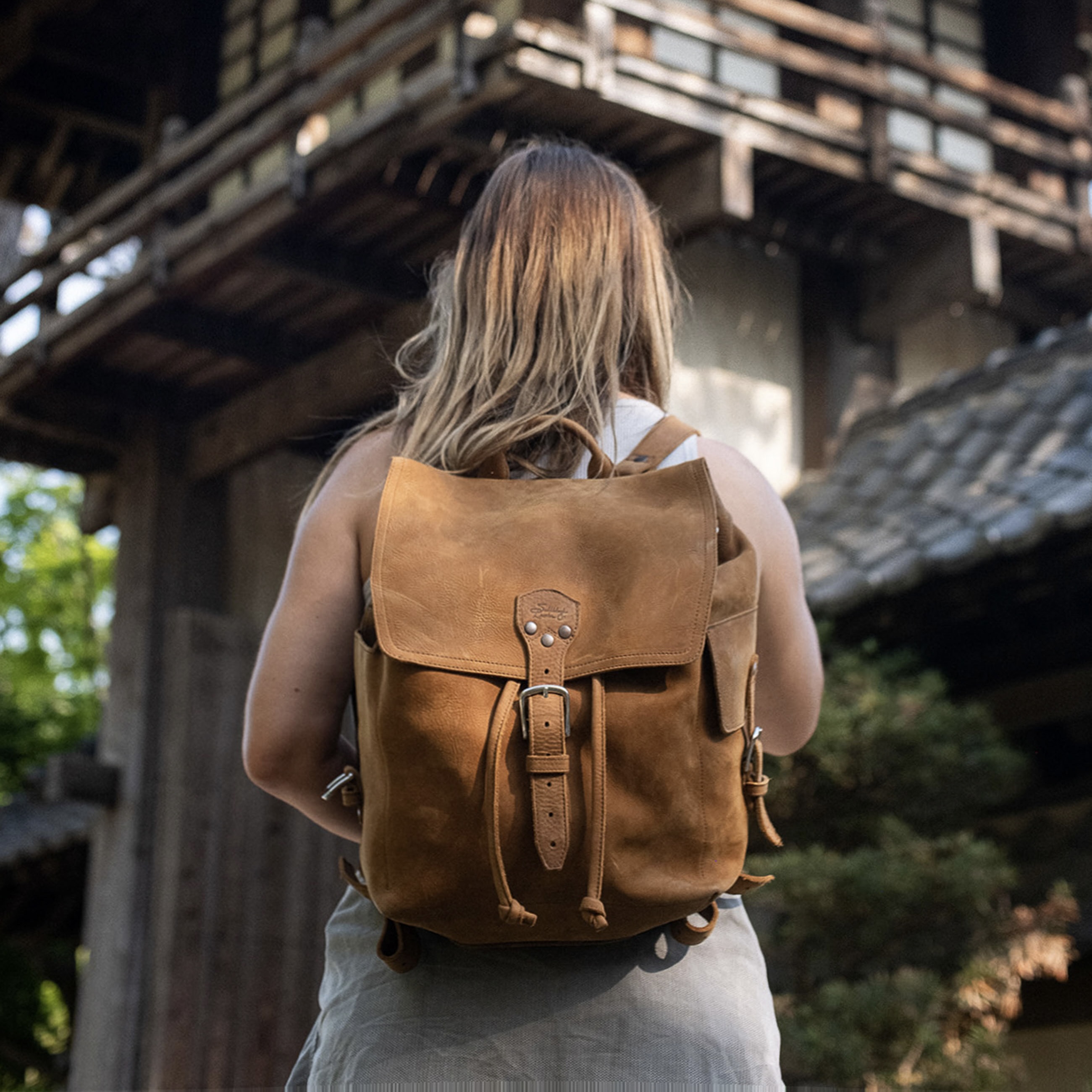 The 16" Full Grain Leather Drawstring Backpack is designed with simplicity and functionality in mind, featuring a wide opening, pigskin-lined back, laptop pocket, and adjustable shoulder straps.